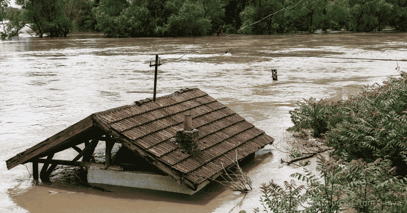 Natural hazards -a photo of flooding with only the roof of a house visible. Photo by Visual Intermezzo-sourced from Canva
